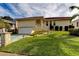 House with red tile roof, attached garage, and lush green lawn at 81 Gulfwinds Dr, Palm Harbor, FL 34683