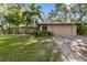 Single-story house with a two-car garage, landscaping and large front yard at 815 Village Way, Palm Harbor, FL 34683