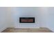 Modern electric fireplace with black frame and faux logs installed on a shiplap wall and laminate flooring at 925 E Chelsea St, Tampa, FL 33603