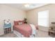 Cozy bedroom with full-size bed and window at 25028 Hyde Park Blvd, Land O Lakes, FL 34639