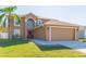 Two-story house with a red door, attached garage, and well-manicured lawn at 25028 Hyde Park Blvd, Land O Lakes, FL 34639