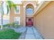 Front entrance with red door, walkway, and landscaping at 25028 Hyde Park Blvd, Land O Lakes, FL 34639