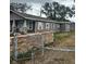 One-story home with grey siding, stone wall, and chain link fence at 3505 E Mcberry St, Tampa, FL 33610