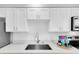 Beautiful kitchen featuring white cabinetry, quartz countertops and stainless steel faucet at 4444 Swift Rd # 20, Sarasota, FL 34231