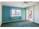 Bedroom with green carpet, water view, and access to a balcony at 4859 Independence Dr, Bradenton, FL 34210