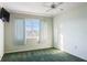 Bright bedroom featuring green carpeting and a large window at 4859 Independence Dr, Bradenton, FL 34210