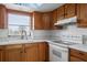 Kitchen features wood cabinets, white appliances, and a cooktop at 4859 Independence Dr, Bradenton, FL 34210