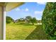 Landscaped backyard with lush lawn and lake view at 4930 Cedar Oak Way, Sarasota, FL 34233