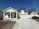 Charming new construction home featuring a two-car garage, white siding, and well-manicured lawn at 5137 4Th N Ave, St Petersburg, FL 33710