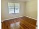 Bright bedroom with hardwood floors and a large window at 1003 Beverly Ave, Largo, FL 33770