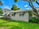 Side view of a charming house with a large lawn and striped awnings at 1003 Beverly Ave, Largo, FL 33770