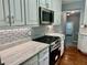 Updated kitchen with white cabinets, granite countertops and stainless steel appliances at 1003 Beverly Ave, Largo, FL 33770