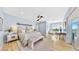 Bright main bedroom with wood floors, a sitting area, ceiling fan and balcony, creating a serene retreat at 10101 Eagle Preserve Dr, Englewood, FL 34224