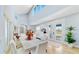 The dining room features wood floors, white chairs, and an abundance of natural light from large windows at 10101 Eagle Preserve Dr, Englewood, FL 34224
