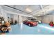 Organized garage featuring two cars, tools, ample storage, and an epoxy coated floor at 10101 Eagle Preserve Dr, Englewood, FL 34224