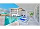Luxury pool area with lounge chairs, a covered patio, and views of the two-story home at 10101 Eagle Preserve Dr, Englewood, FL 34224