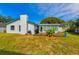 View of home's back and grassy yard at 1040 Kent Ln, Palm Harbor, FL 34683