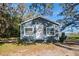 Gray house with white door and windows, surrounded by trees at 3106 E Trapnell Rd, Plant City, FL 33566
