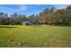 Spacious grassy yard with shed and trees in background at 3106 E Trapnell Rd, Plant City, FL 33566