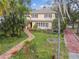 Aerial view of the home's landscaped front yard, brick walkway, and proximity to mature trees at 4611 W Lowell Ave, Tampa, FL 33629