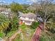 Charming two-story home with red shutters, a brick pathway, and mature trees in a lush, landscaped yard at 4611 W Lowell Ave, Tampa, FL 33629
