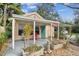 Charming front porch with colorful door and a cozy seating area surrounded by lush greenery at 4611 W Lowell Ave, Tampa, FL 33629