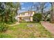 Beautiful home surrounded by mature trees and greenery with a brick walkway and driveway at 4611 W Lowell Ave, Tampa, FL 33629
