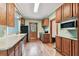 Functional kitchen with wooden cabinets, laminate countertops, and classic appliances with hardwood floors at 4611 W Lowell Ave, Tampa, FL 33629