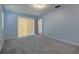 Spacious bedroom with light blue walls, gray carpet and sliding door at 5004 S Hesperides St, Tampa, FL 33611