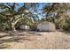 Two storage buildings in a wooded backyard setting at 5255 Azalea Cir, Dade City, FL 33523