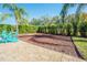 Backyard lounge area, featuring Adirondack chairs and mature landscaping at 5709 White Trillium Loop, Land O Lakes, FL 34639