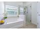 Bright bathroom featuring a soaking tub and glass enclosed shower stall at 5709 White Trillium Loop, Land O Lakes, FL 34639