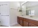Bathroom featuring double sinks, wood cabinets, and glass enclosed shower at 5709 White Trillium Loop, Land O Lakes, FL 34639