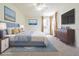 Cozy bedroom features bedside tables, a large window and a dresser with a tv at 5709 White Trillium Loop, Land O Lakes, FL 34639