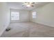 Spacious bedroom with neutral carpet, base molding, two windows, and a ceiling fan at 5709 White Trillium Loop, Land O Lakes, FL 34639