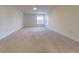 A spacious bonus room with plush carpeting and ample natural light provides a versatile living area at 5709 White Trillium Loop, Land O Lakes, FL 34639