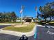 Exterior view of the community clubhouse with an American flag, surrounded by palm trees and green landscaping at 5709 White Trillium Loop, Land O Lakes, FL 34639