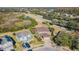 Aerial view of a two-story home with a well-manicured lawn, a paved driveway, and mature trees at 5709 White Trillium Loop, Land O Lakes, FL 34639