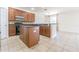 Well-equipped kitchen featuring dark wood cabinets, black appliances, and a breakfast bar with adjacent dining area at 5709 White Trillium Loop, Land O Lakes, FL 34639