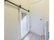 Bright laundry room with a distinctive sliding barn door and convenient access to additional spaces at 5709 White Trillium Loop, Land O Lakes, FL 34639