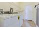 A well-lit laundry room features a washer, dryer, wire shelving, and a sliding barn door at 5709 White Trillium Loop, Land O Lakes, FL 34639