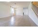 Open-concept living room with ceramic tile, staircase, and chandelier at 5709 White Trillium Loop, Land O Lakes, FL 34639