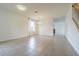 Bright, open-concept living room with tile floors and staircase view at 5709 White Trillium Loop, Land O Lakes, FL 34639