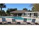 Exterior view of a community pool and clubhouse with lounge chairs and shaded seating areas at 5709 White Trillium Loop, Land O Lakes, FL 34639
