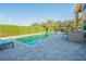Backyard in-ground pool with a lounging area and an outdoor kitchen at 5709 White Trillium Loop, Land O Lakes, FL 34639