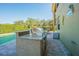 Poolside outdoor kitchen featuring a granite counter, tile backsplash, and stainless steel grill at 5709 White Trillium Loop, Land O Lakes, FL 34639