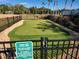 Putting green in Dupree Lakes, with rules posted, surrounded by fence and landscaping at 5709 White Trillium Loop, Land O Lakes, FL 34639