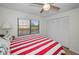 Bedroom with red and white striped bedding, window, and white closet doors at 5817 Park N St # 204, St Petersburg, FL 33709