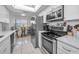 Well-lit kitchen featuring stainless steel appliances, bright white cabinets, and tile flooring at 5817 Park N St # 204, St Petersburg, FL 33709