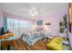 Charming bedroom with floral bedding, light wood floors, and ceiling fan at 5820 43Rd N Ter # 1403, St Petersburg, FL 33709